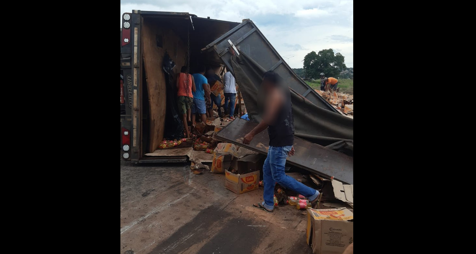 Imagem mostra moradores saqueando carga de óleo após acidente com caminhão. - Foto: Divulgação
